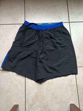 vintage Speedo men's swim trunks feature a black colorway with blue side panels